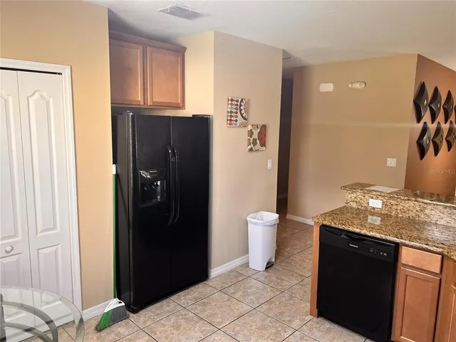 a kitchen with stainless steel appliances granite countertop a refrigerator and a sink
