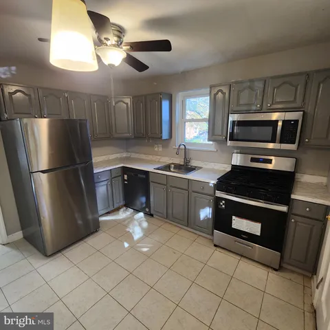 a kitchen with stainless steel appliances granite countertop a refrigerator a stove a sink and a microwave