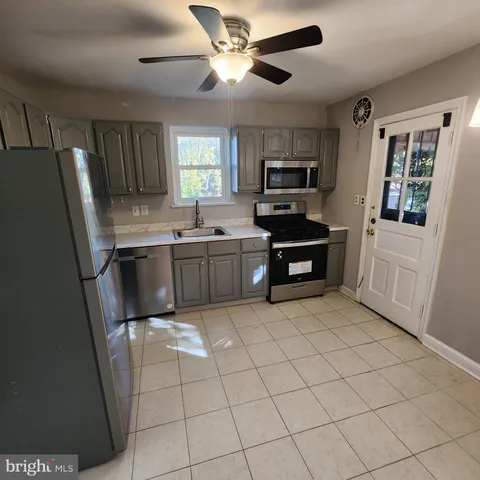 a kitchen with stainless steel appliances a stove a sink and a refrigerator