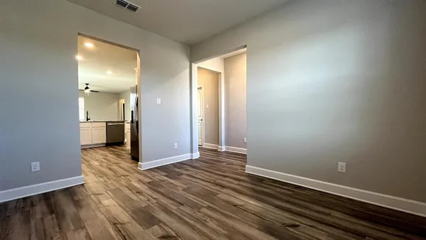 an empty room with wooden floor and a bathroom