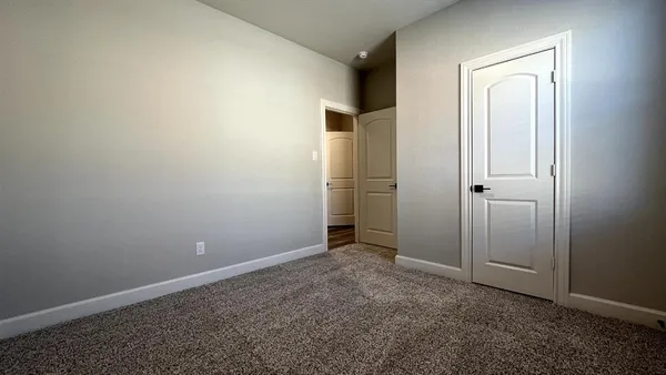 an empty room with closet and windows