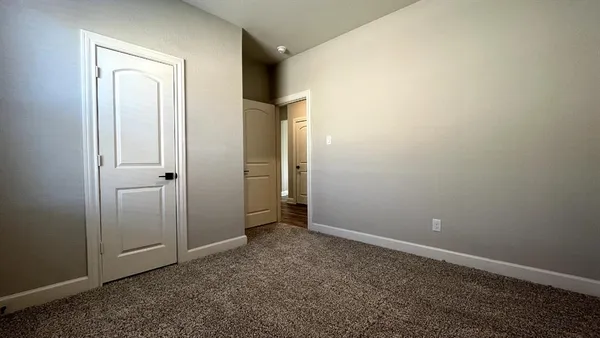 an empty room with closet and a bathroom