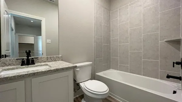 a bathroom with a granite countertop toilet a sink and bathtub
