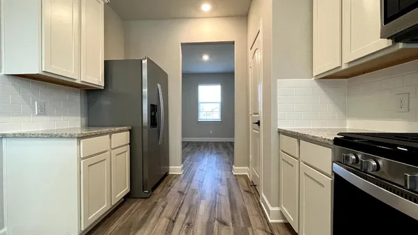 a kitchen with white cabinets and stainless steel appliances
