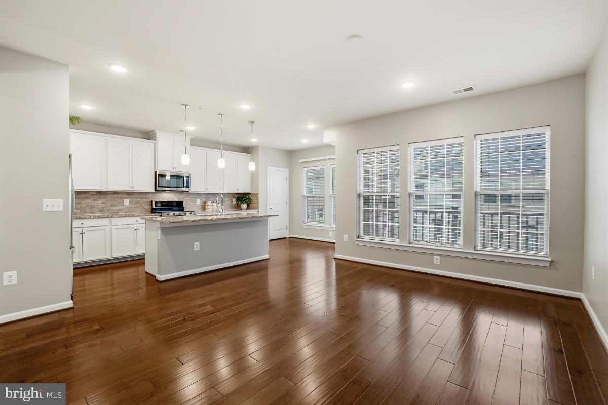 23517 Public House Road, Unit H Clarksburg, MD 20871 - Photo 15 of 49 a kitchen with stainless steel appliances granite countertop a stove top oven a sink and a microwave