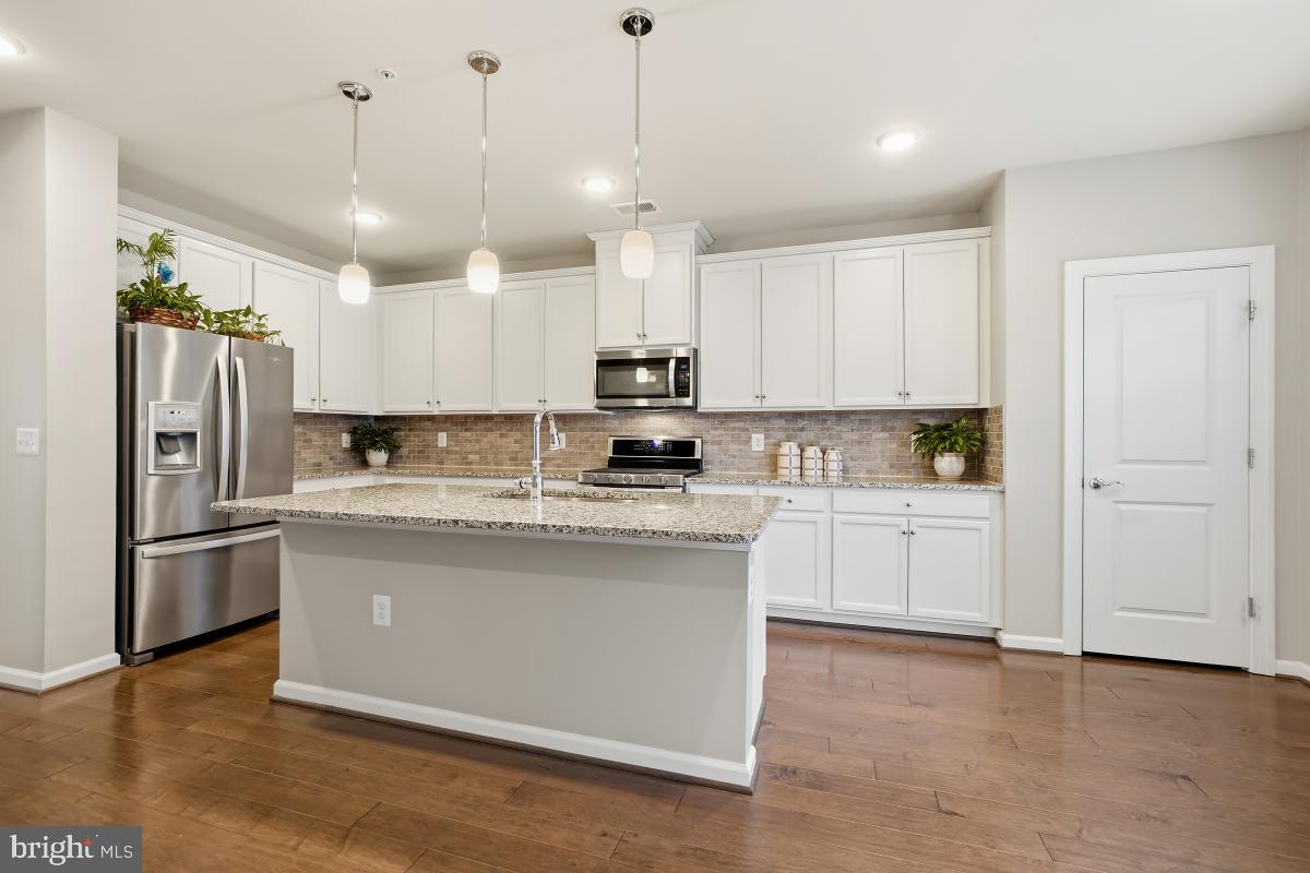 23517 Public House Road, Unit H Clarksburg, MD 20871 - Photo 19 of 49 a kitchen with stainless steel appliances granite countertop a refrigerator a stove a sink and a microwave