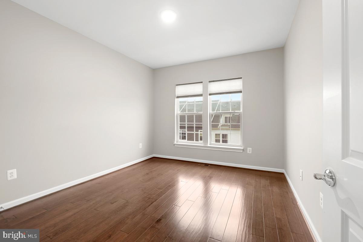 23517 Public House Road, Unit H Clarksburg, MD 20871 - Photo 38 of 49 an empty room with wooden floor and windows