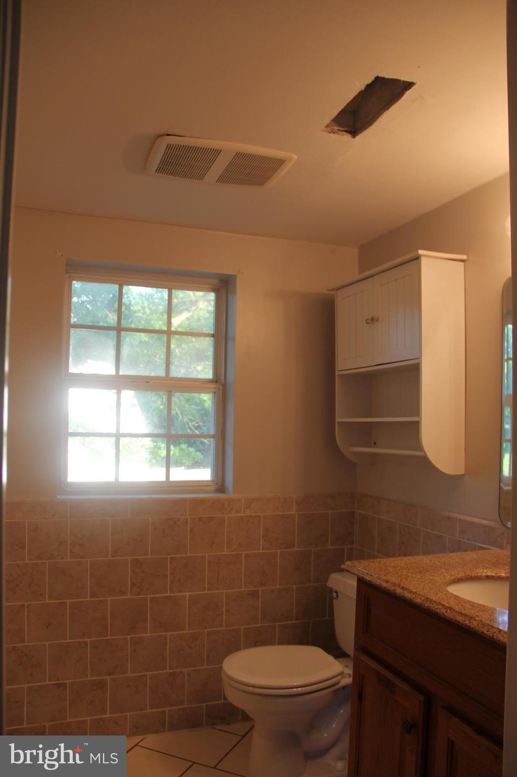 9509 Rocky Ridge Road Rocky Ridge, MD 21778 - Photo 18 of 25 a bathroom with a toilet a sink and mirror