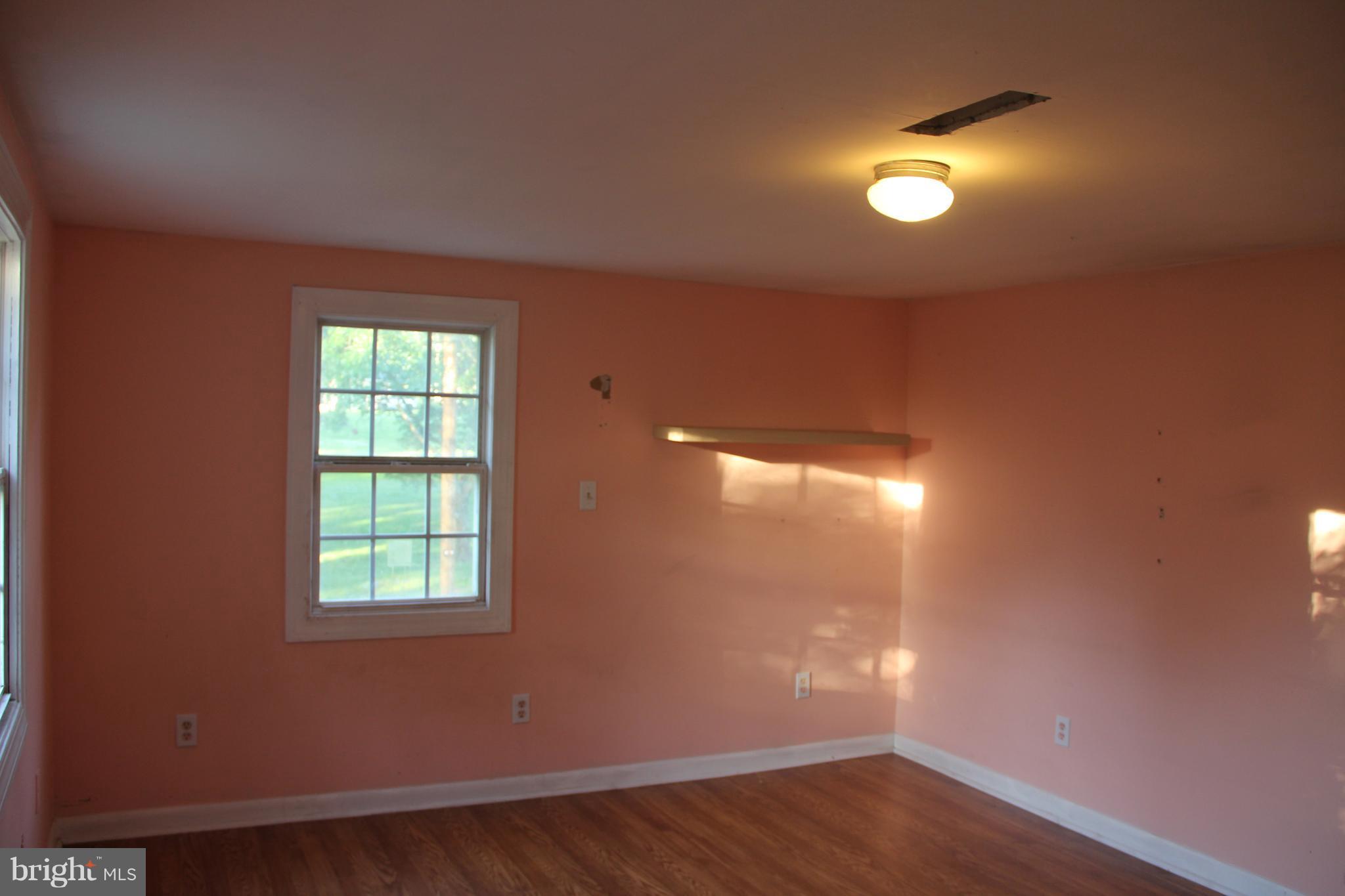 9509 Rocky Ridge Road Rocky Ridge, MD 21778 - Photo 20 of 25 an empty room with wooden floor and windows