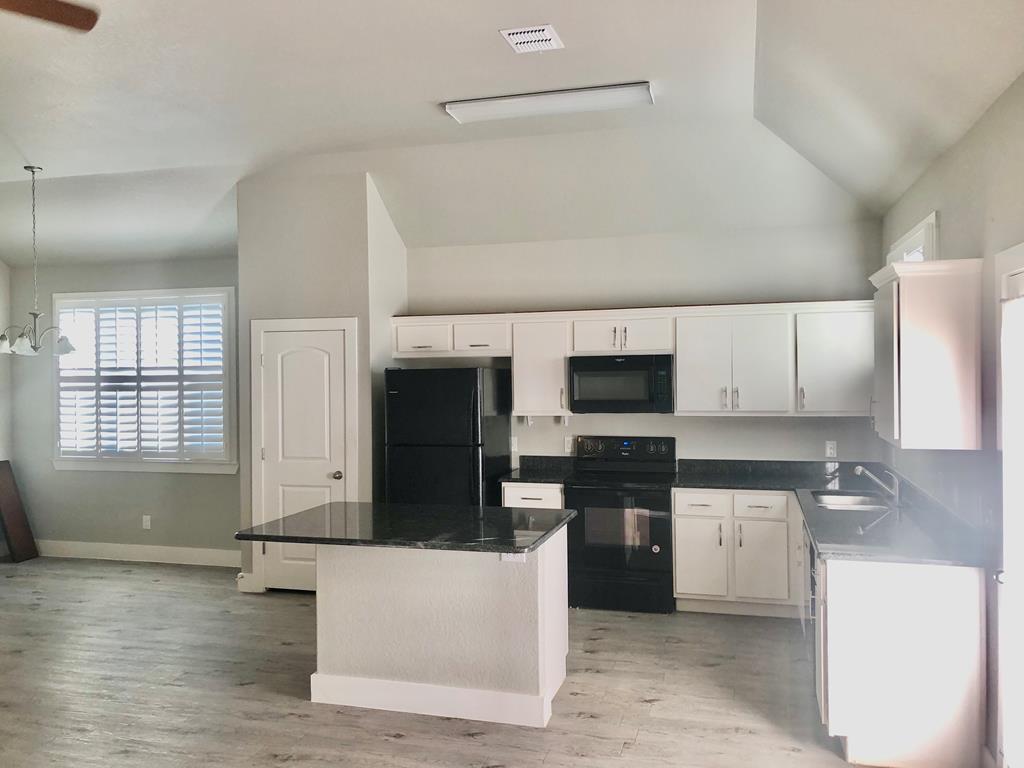 229 Riley Lane Fredericksburg, TX 78624 - Photo 6 of 16 a kitchen with stainless steel appliances a stove top oven a sink a microwave and a refrigerator