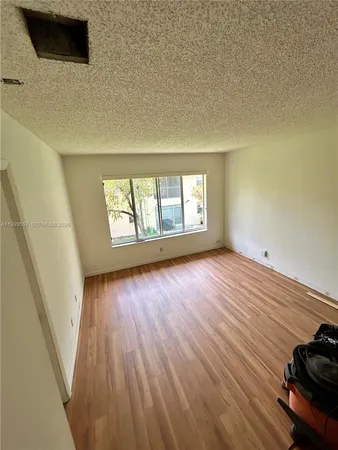 a view of a livingroom with wooden floor and window