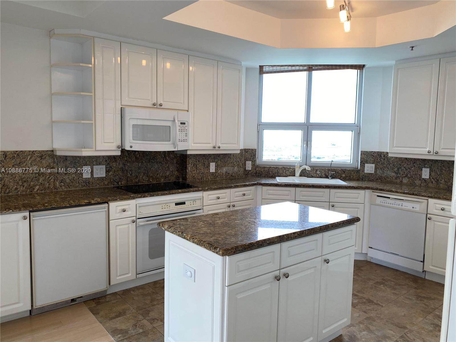 808 Brickell Key Drive, Unit 2601 Miami, FL 33131 - Photo 11 of 29 a kitchen with granite countertop white cabinets sink and window