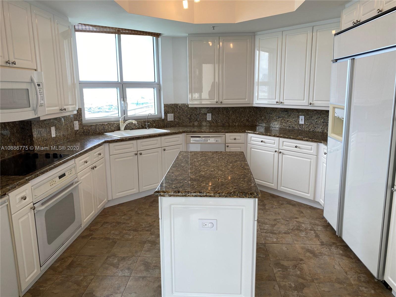 808 Brickell Key Drive, Unit 2601 Miami, FL 33131 - Photo 12 of 29 a kitchen with granite countertop white cabinets white appliances a sink and a window