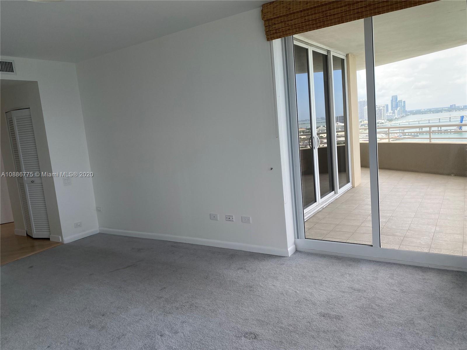 808 Brickell Key Drive, Unit 2601 Miami, FL 33131 - Photo 16 of 29 an empty room with sliding door and wooden floor