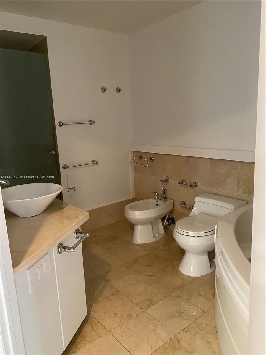 808 Brickell Key Drive, Unit 2601 Miami, FL 33131 - Photo 23 of 29 a white toilet sitting next to a bathroom sink and a toilet