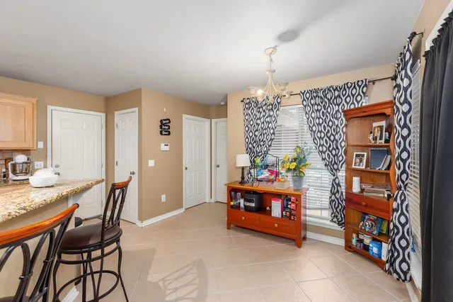 a kitchen with stainless steel appliances a dining table chairs and a refrigerator