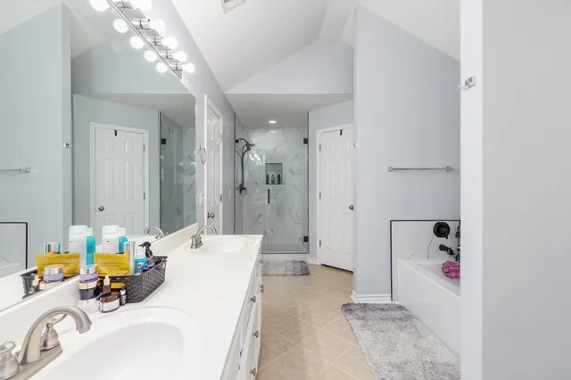 a spacious bathroom with a shower sink double mirror and shower