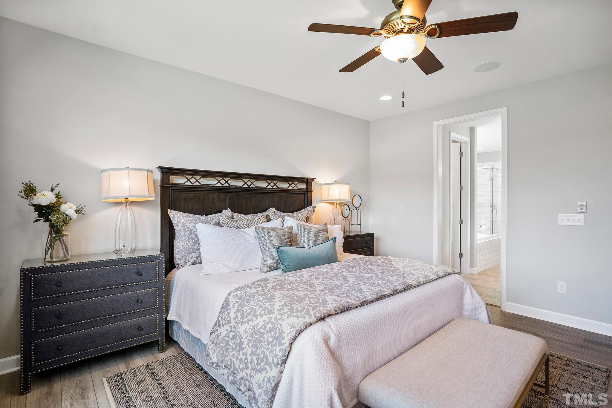 1016 Manchaca Loop, Unit 4 Apex, NC 27539 - Photo 20 of 36 a bedroom with a bed and wooden floor