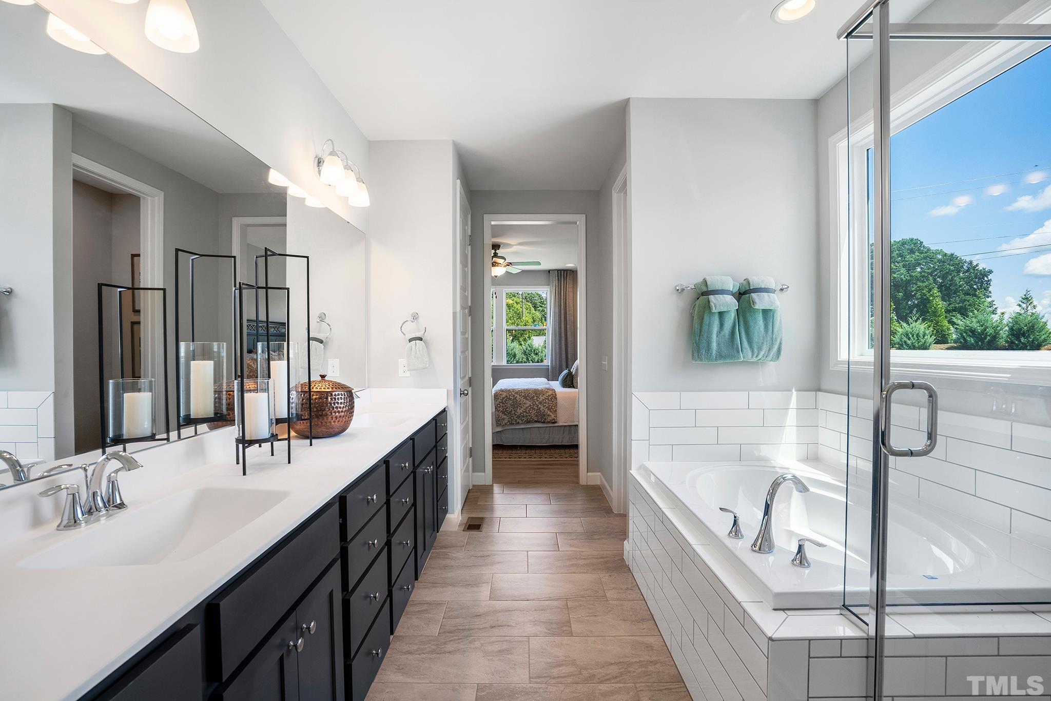 1016 Manchaca Loop, Unit 4 Apex, NC 27539 - Photo 22 of 36 a en suite spacious bathroom with a double vanity sink a mirror and a bathtub