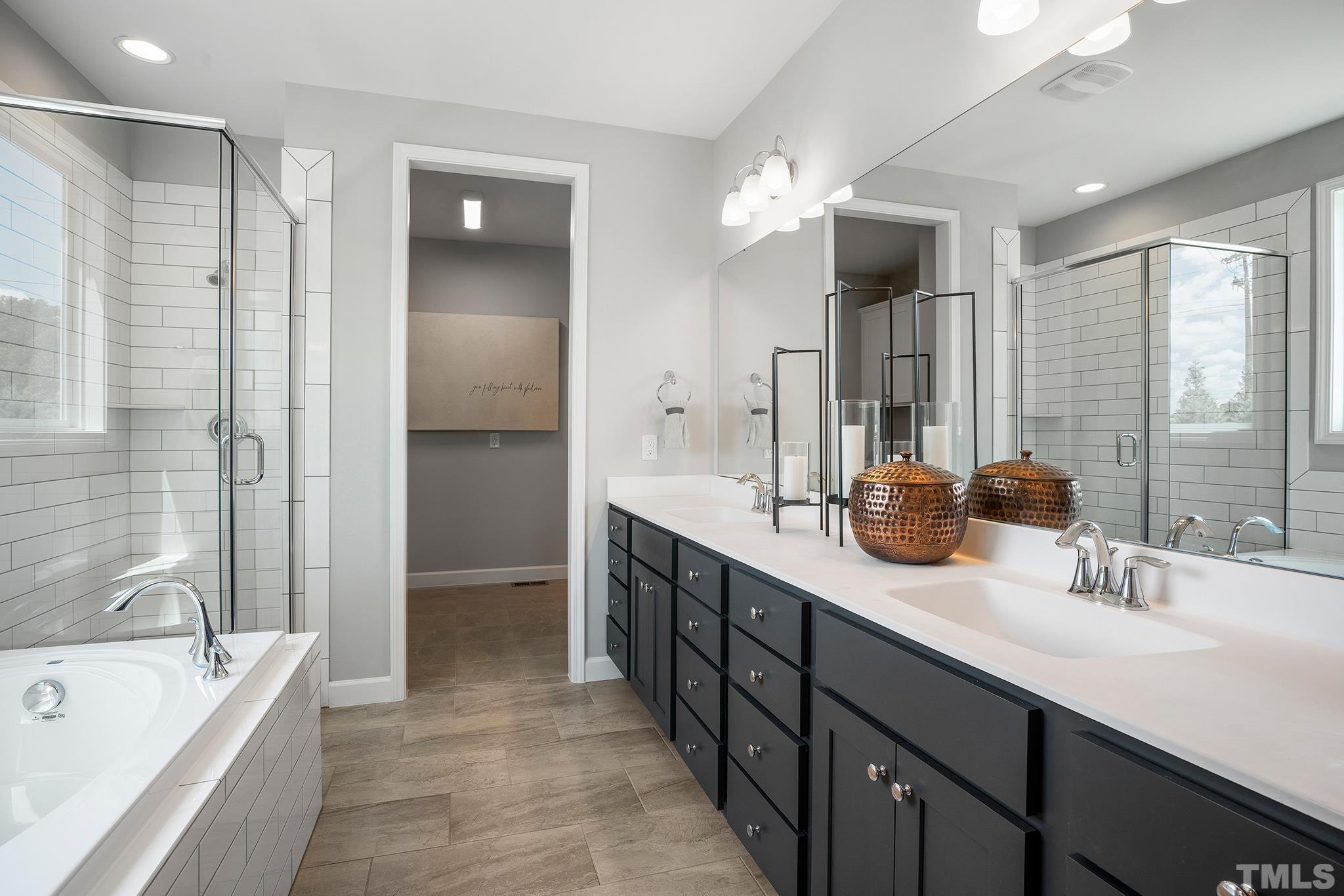 1016 Manchaca Loop, Unit 4 Apex, NC 27539 - Photo 23 of 36 a bathroom with a tub a sink double vanity and a shower