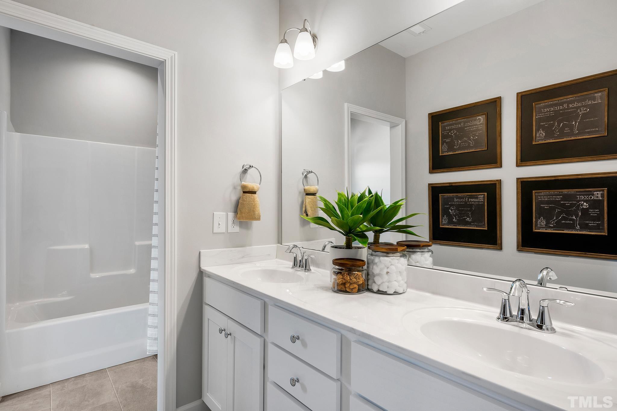 1016 Manchaca Loop, Unit 4 Apex, NC 27539 - Photo 30 of 36 a bathroom with a double vanity sink a potted plant and a shower
