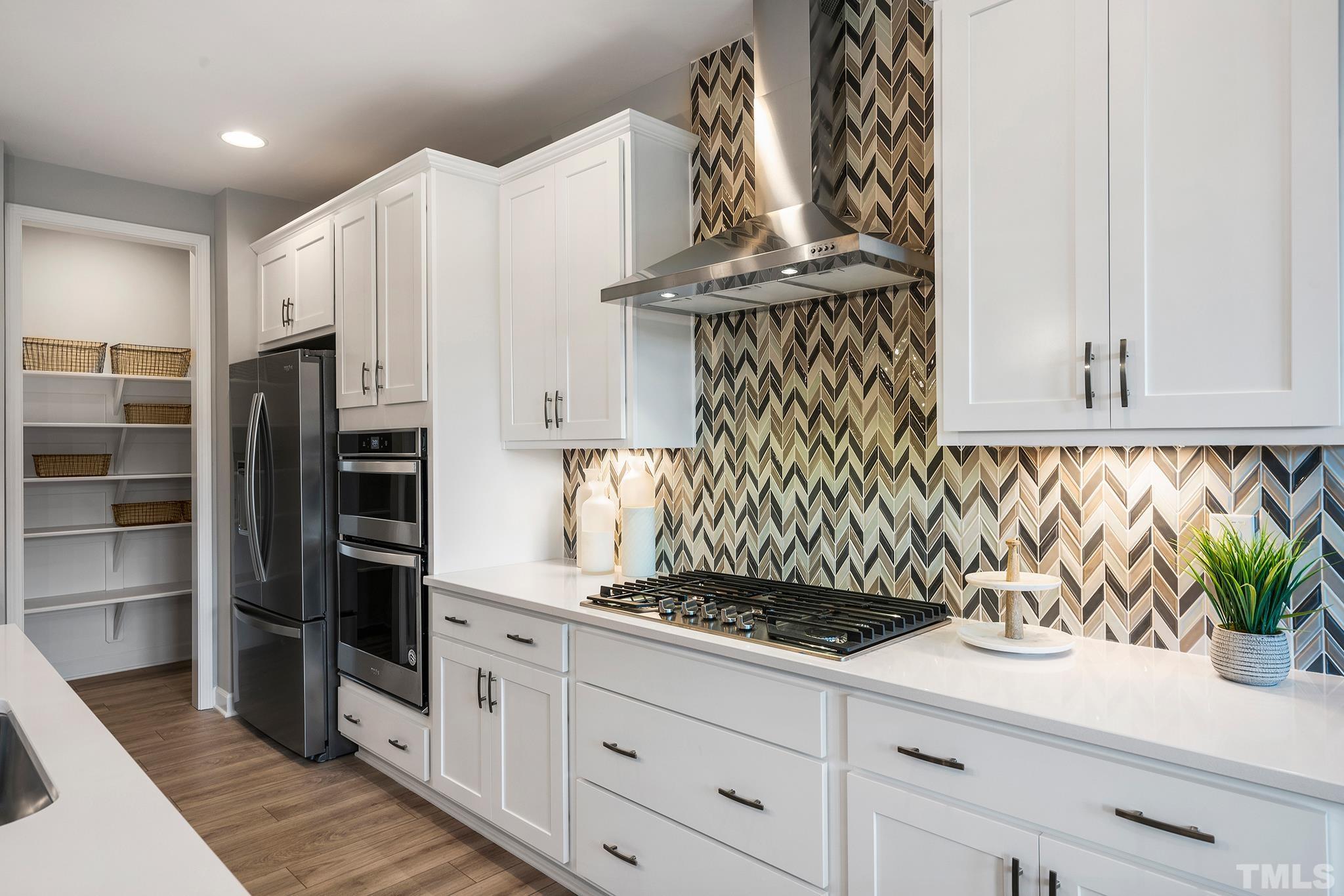 1016 Manchaca Loop, Unit 4 Apex, NC 27539 - Photo 4 of 36 a kitchen with granite countertop white cabinets and stainless steel appliances