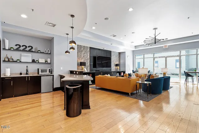 a living room with furniture a flat screen tv and kitchen view