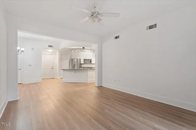 wooden floor in an empty room with a kitchen