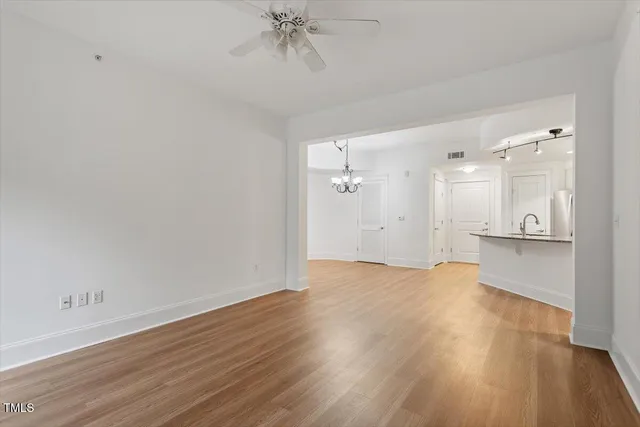 a view of a room with wooden floor and a ceiling fan