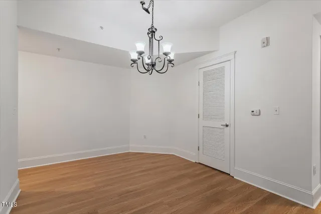 a view of empty room with wooden floor and ceiling fan