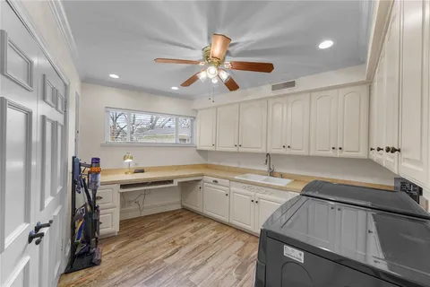 a kitchen with white cabinets sink and stainless steel appliances