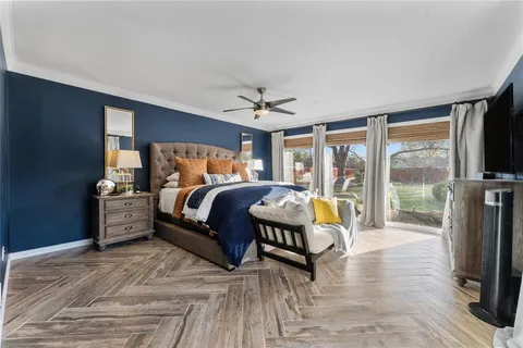 a bedroom with a bed and a large window with outer view