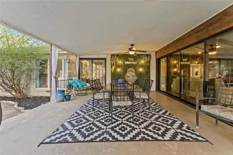 a living room with patio furniture and a potted plant