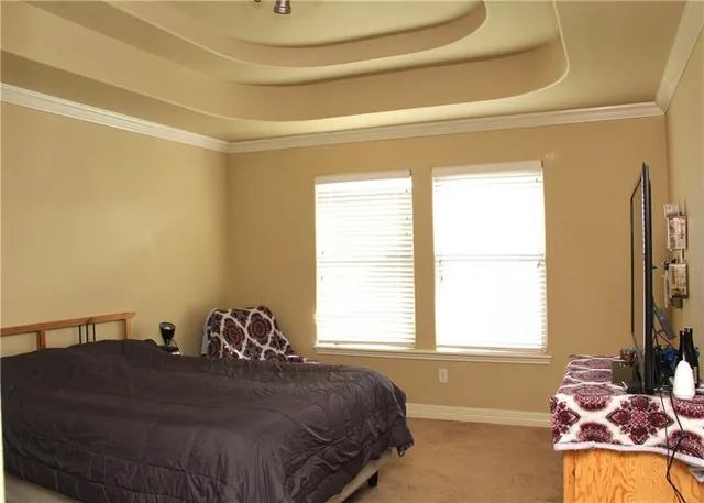 a bed sitting in a bedroom next to a window