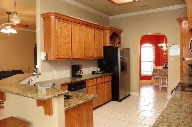 a kitchen with stainless steel appliances granite countertop a refrigerator stove and sink