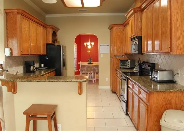 a kitchen with stainless steel appliances granite countertop a sink a stove and refrigerator