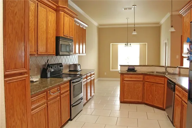 a kitchen with stainless steel appliances granite countertop a sink stove and cabinets