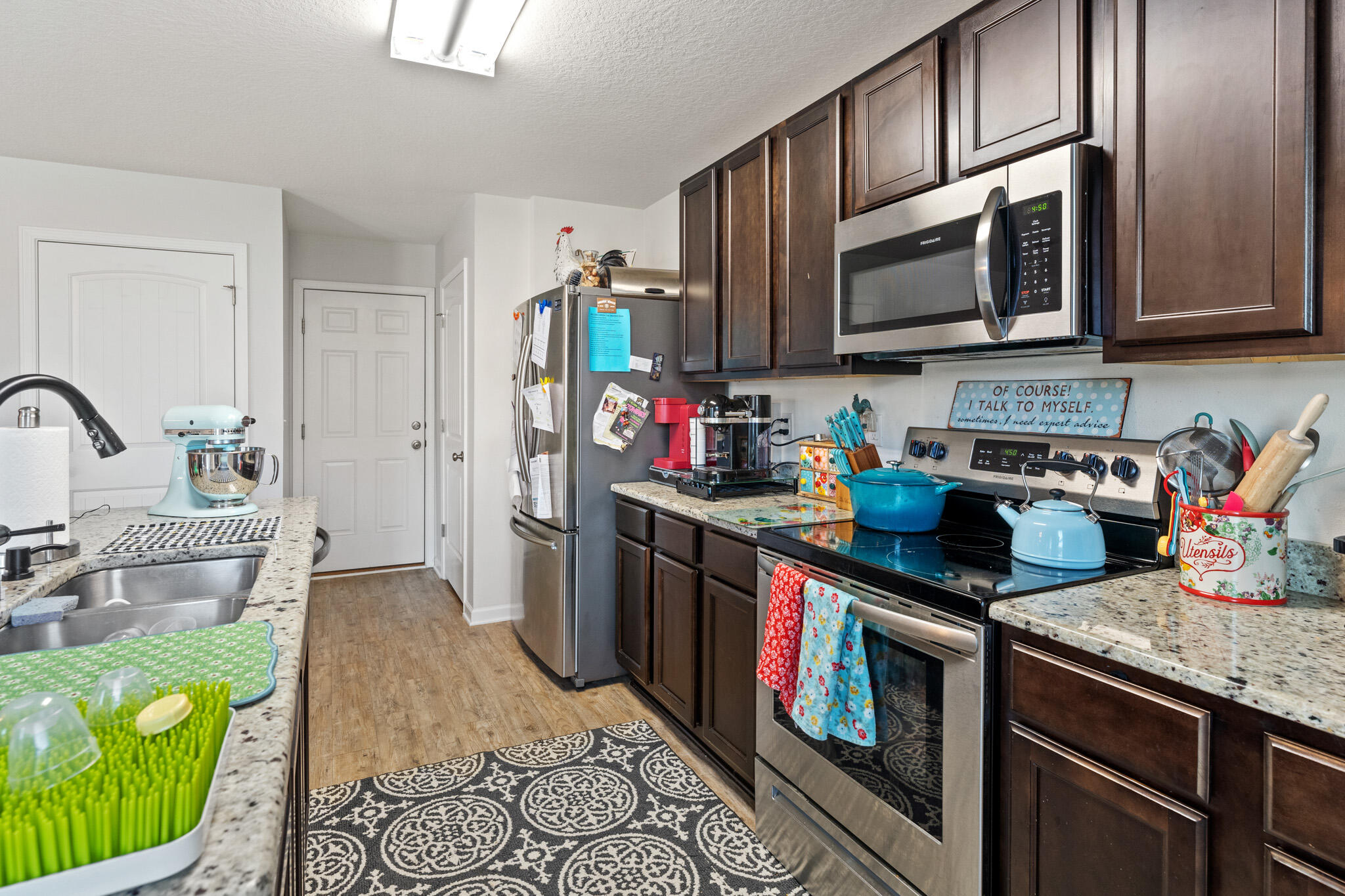 745 Widgeon Way Crestview, FL 32539 - Photo 9 of 29 a kitchen with stainless steel appliances granite countertop a stove a sink and a microwave