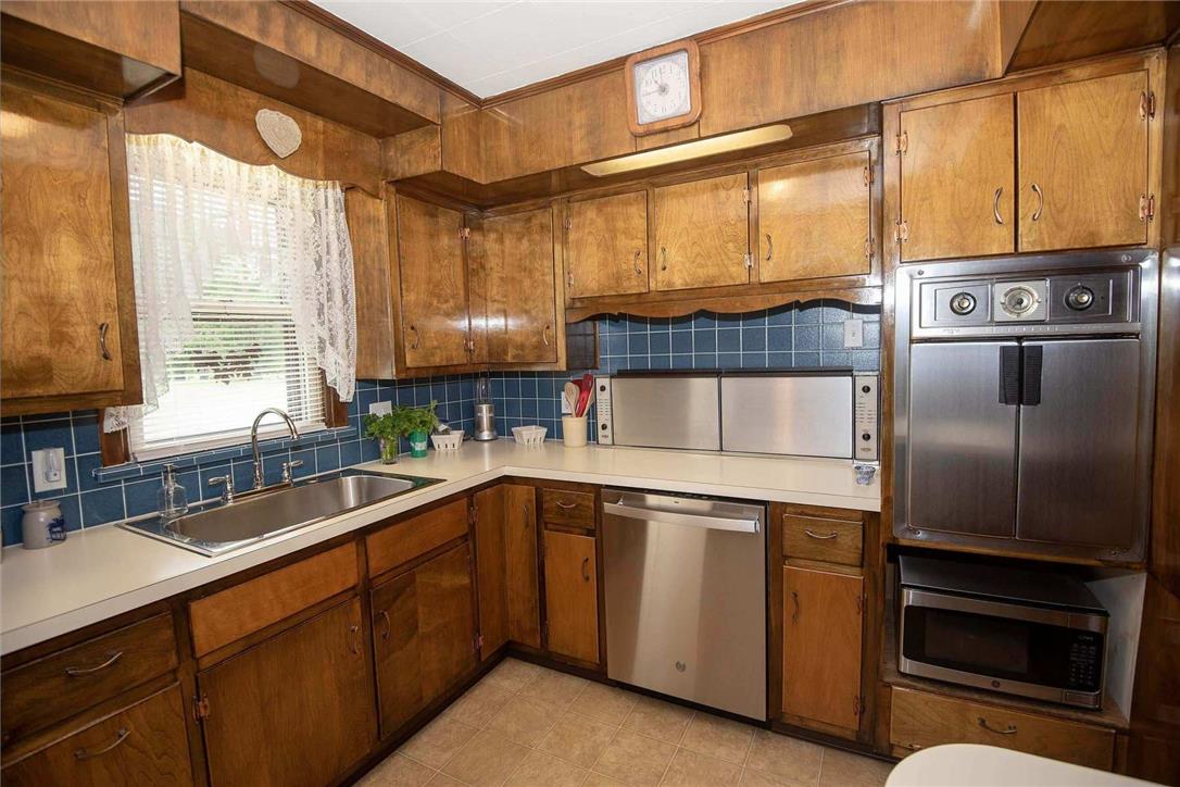 706 Stones Crossing Road Easton, PA 18045 - Photo 10 of 40 Timeless wood cabinetry defines this compact kitchen, featuring a double-basin sink and stainless steel appliances.