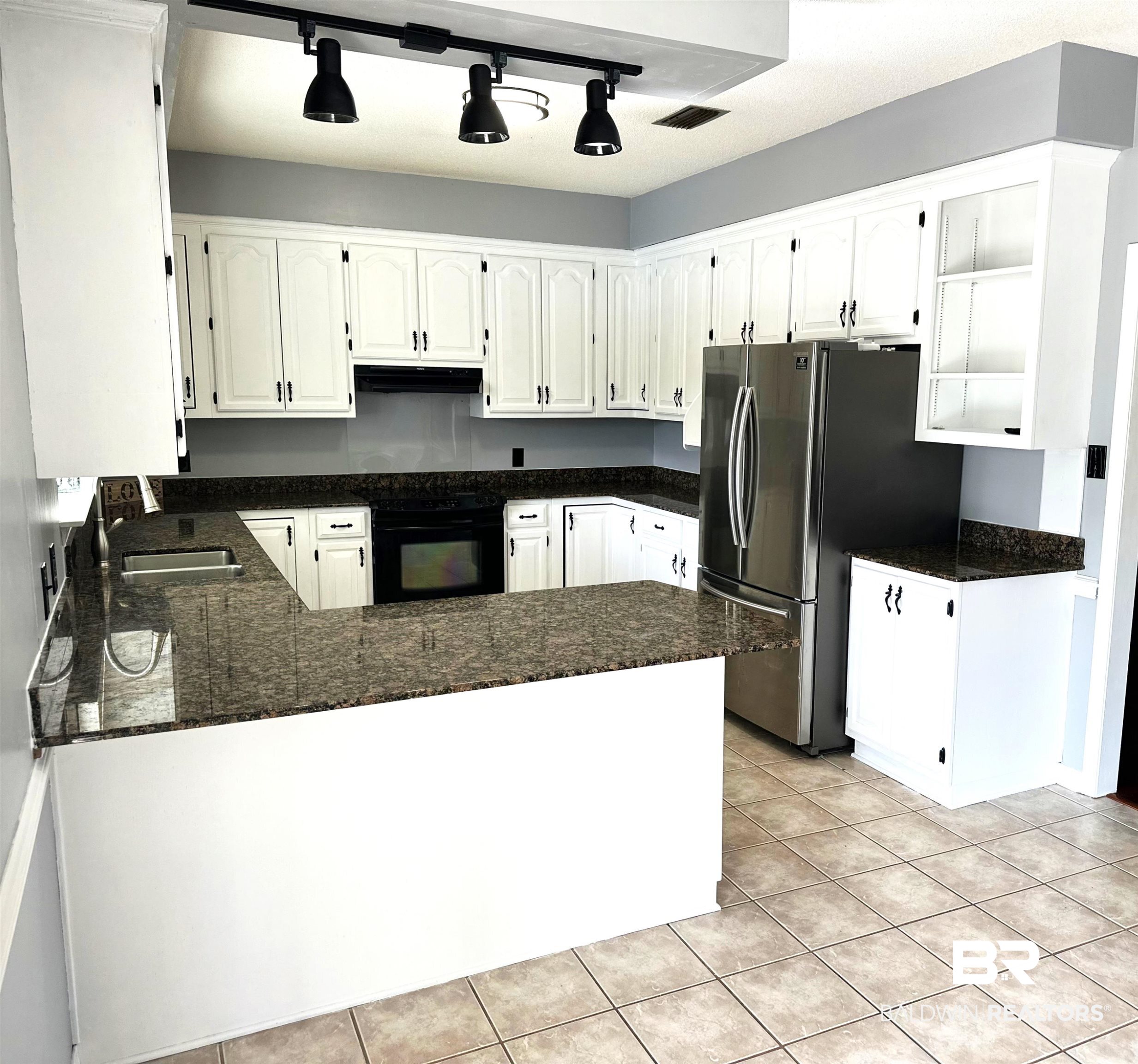 100 Orleans Way Daphne, AL 36526 - Photo 10 of 31 Kitchen featuring sink, white cabinetry, light tile patterned floors, stainless steel fridge, and kitchen peninsula