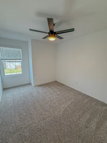 a view of a livingroom with a ceiling fan and hardwood floor