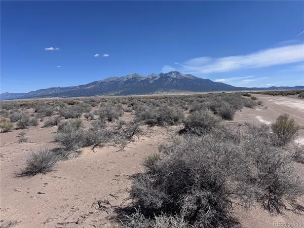 a view of a dry yard with mountains in the background