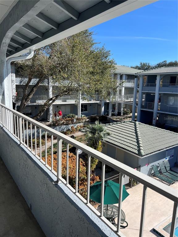 a view of a balcony with two chairs and wooden floor