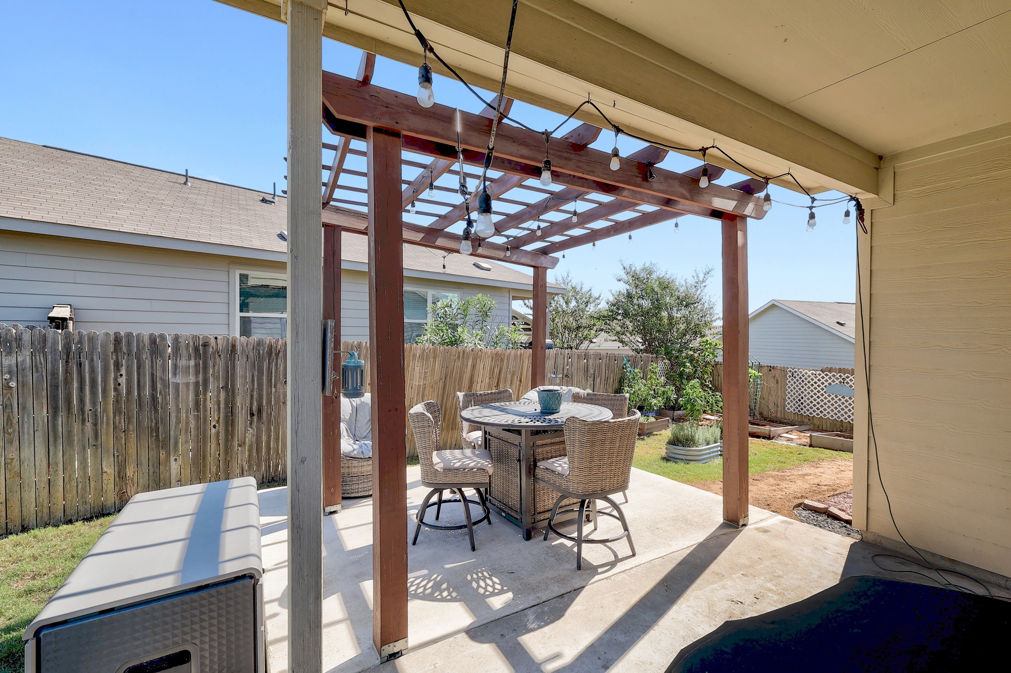 735 Circle Way Jarrell, TX 76537 - Photo 25 of 32 A concrete patio shaded by a wooden pergola overlooks the fenced yard.