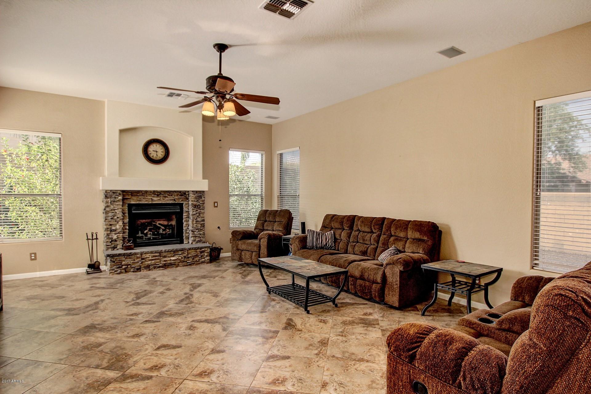 2111 West Caleb Road Phoenix, AZ 85085 - Photo 11 of 39 a living room with furniture a window and a fireplace