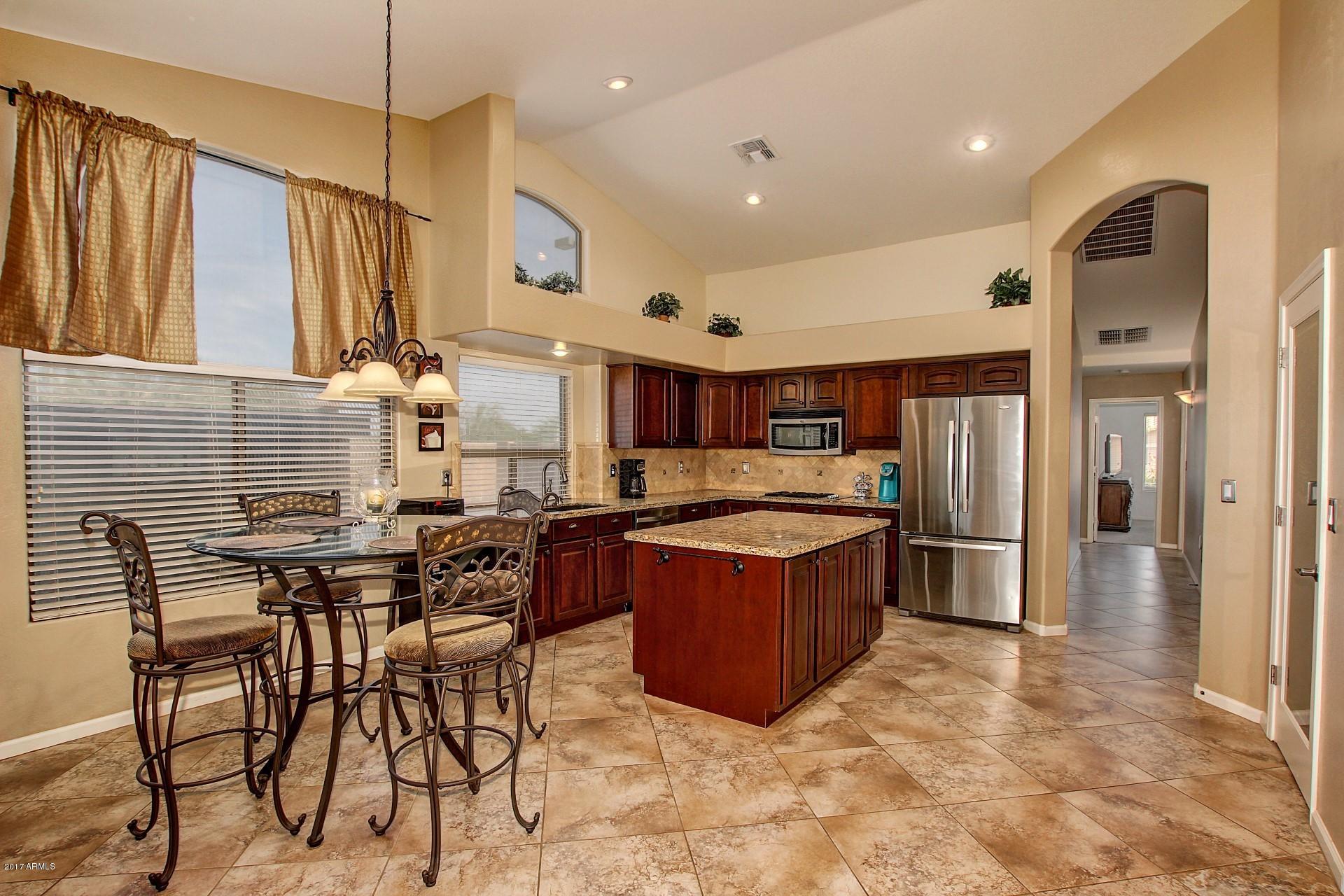 2111 West Caleb Road Phoenix, AZ 85085 - Photo 7 of 39 a kitchen with stainless steel appliances granite countertop a sink and a refrigerator