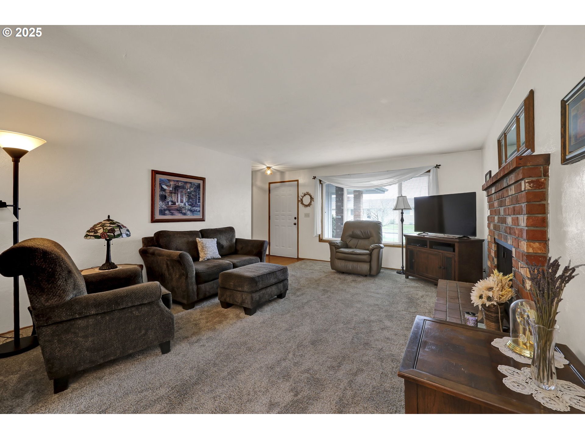 3670 Plumtree Drive Eugene, OR 97402 - Photo 11 of 47 a living room with furniture a flat screen tv and a fireplace