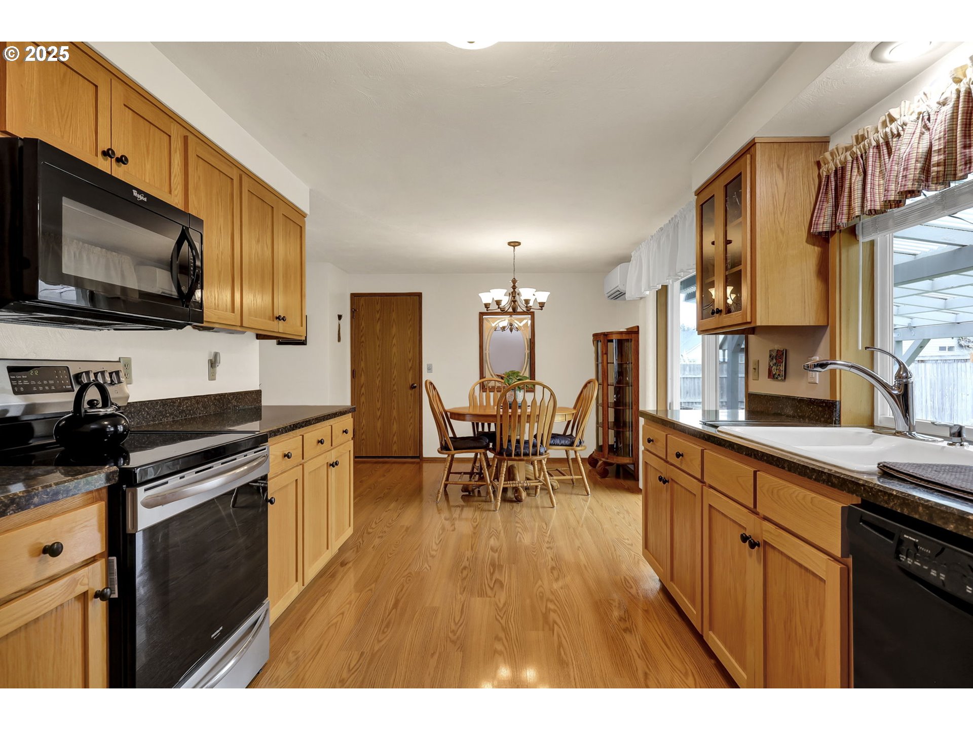 3670 Plumtree Drive Eugene, OR 97402 - Photo 18 of 47 a kitchen with stainless steel appliances granite countertop a stove top oven a sink dishwasher a dining table and chairs with wooden floor