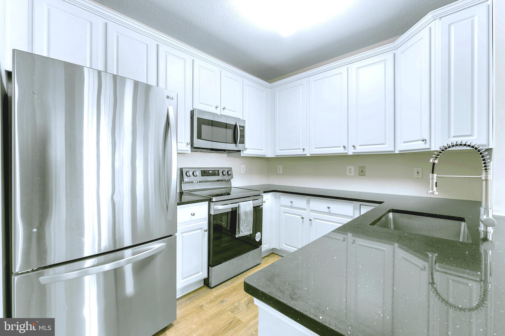 12170 Abington Hall Place, Unit 201 Reston, VA 20190 - Photo 11 of 39 a kitchen with a refrigerator stove and microwave