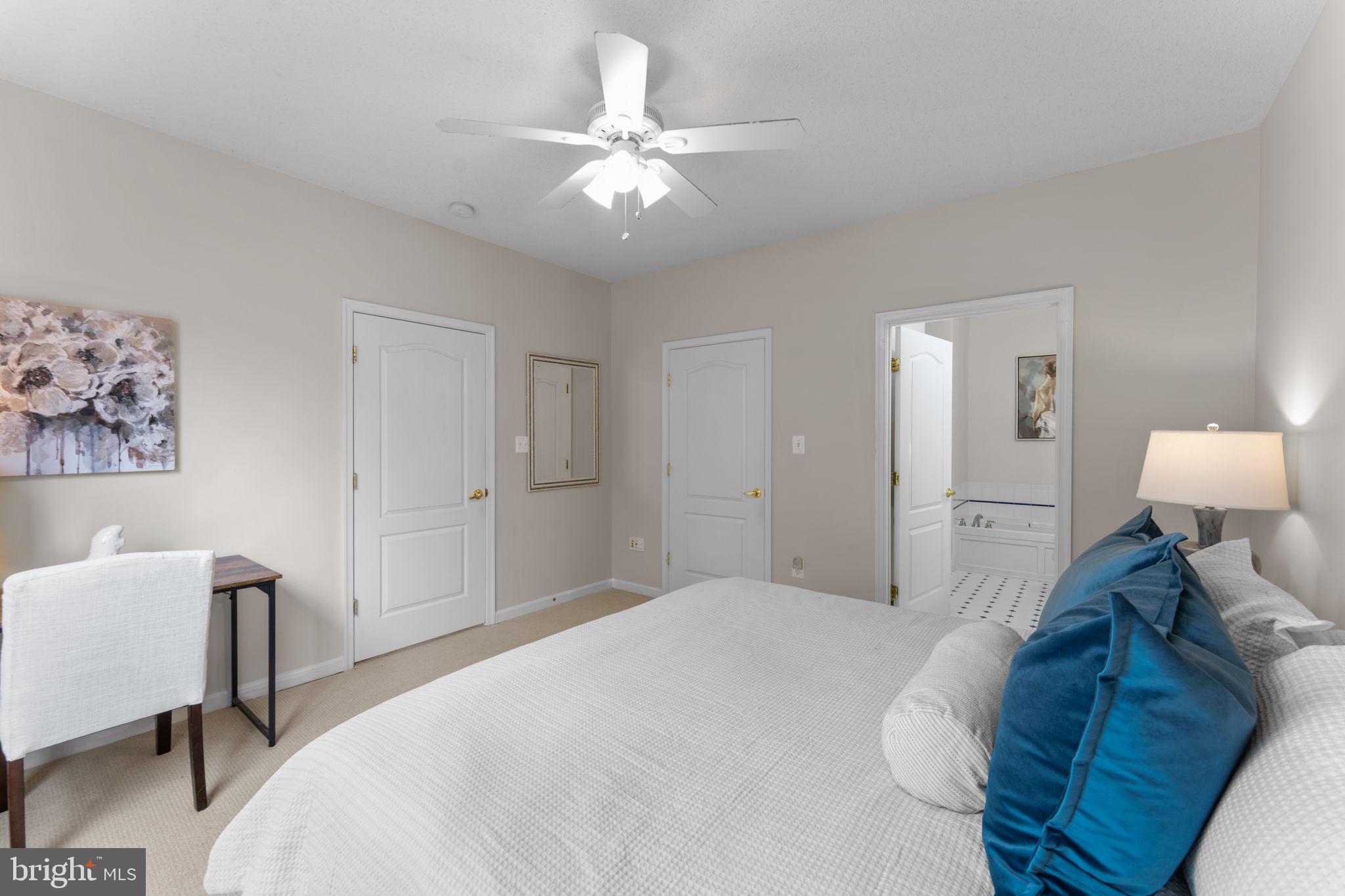 12170 Abington Hall Place, Unit 201 Reston, VA 20190 - Photo 14 of 39 a spacious bedroom with a bed and a chandelier
